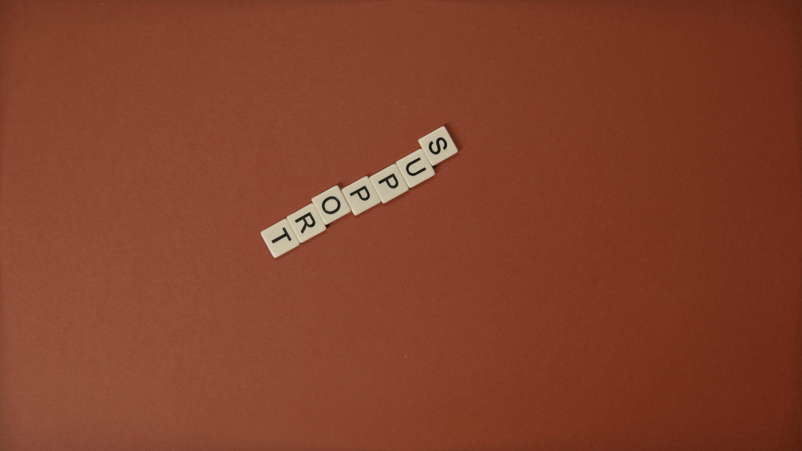 Letter tiles spelling 'Support' on a brown background with ample copy space.